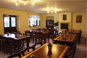 Sala da pranzo rustica con camino e tavoli in legno, perfetta per gustare i piatti tipici del Ristorante campeggio Abruzzo.