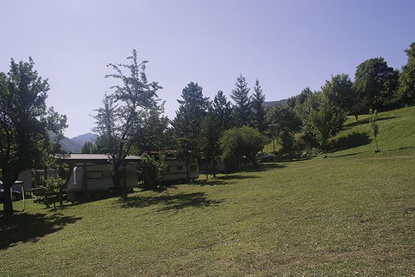 Vacanza in roulotte Abruzzo tra natura e relax: roulotte stanziali circondate da alberi, prati verdi e tranquillità nel Parco Nazionale.