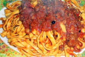 Piatto di fettuccine fatte in casa con sugo rustico abruzzese: sapori autentici della tradizione al Ristorante campeggio Abruzzo.